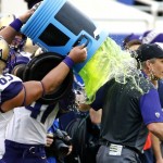 Washington offensive lineman Siosifa Tufunga (65) empties a beverage cooler on head coach Chris Petersen just after Washington's 44-31 victory over Southern Mississippi at the Heart of Dallas Bowl NCAA college football game, Saturday, Dec. 26, 2015, in Dallas. (AP Photo/Ron Jenkins)