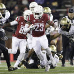 Washington State running back Gerard Wicks (23) carries against Colorado defensive back Jered Bell (21) and defensive back Chidobe Awuzie (4) during the first half of an NCAA college football game, Saturday, Nov. 21, 2015, in Pullman, Wash. (AP Photo/Young Kwak)