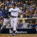 San Diego Padres' Derek Norris heads back to the dugout after striking out in the sixth inning as Seattle Mariners catcher Mike Zunino throws to third during a baseball game Tuesday, June 30, 2015, in San Diego. (AP Photo/Lenny Ignelzi)