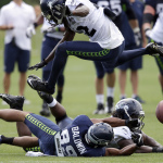 Seattle Seahawks cornerback Terrance Parks leaps in the air after linebacker Horace Miller, lower right, broke up a pass intended for wide receiver Doug Baldwin (89) during practice drills, Saturday, Aug. 2, 2014, at NFL football training camp in Renton, Wash. (AP Photo/Ted S. Warren)