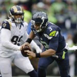 Seattle Seahawks quarterback Russell Wilson (3) is chased by St. Louis Rams' William Hayes in the first half of an NFL football game, Sunday, Dec. 27, 2015, in Seattle. (AP Photo/John Froschauer)