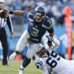 Seattle Seahawks quarterback Russell Wilson (3) runs by Carolina Panthers defensive end Jared Allen (69) during the first half of an NFL divisional playoff football game, Sunday, Jan. 17, 2016, in Charlotte, N.C. (AP Photo/Bob Leverone)