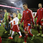 FC Dallas players in red and Seattle Sounders FC players in green take the field before the first half of an MLS soccer western conference semifinal playoff match Sunday, Nov. 8, 2015, in Frisco, Texas. Dallas won 4-2 on penalty kicks. FC Dallas midfielder Michael Barrios (21) is in the foreground. (AP Photo/Brad Loper)