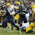 Green Bay Packers defensive end Josh Boyd (93) grabs the jersey of Seattle Seahawks running back Marshawn Lynch, left, as Lynch runs for a touchdown in the second half of an NFL football game, Thursday, Sept. 4, 2014, in Seattle. (AP Photo/Scott Eklund)