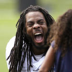 Seattle Seahawks' Richard Sherman shares a laugh with the daughter of a teammate after an NFL football training camp Monday, Aug. 3, 2015, in Renton, Wash. (AP Photo/Elaine Thompson)