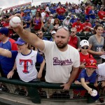 Fans clamor for autographs before a spring training baseball game between the Texas Rangers and the Seattle Mariners Sunday, March 6, 2016, in Surprise, Ariz. (AP Photo/Charlie Riedel)