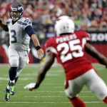 Seattle Seahawks quarterback Russell Wilson (3) throws as Arizona Cardinals cornerback Jerraud Powers (25) looks on during the first half of an NFL football game, Sunday, Jan. 3, 2016, in Glendale, Ariz. (AP Photo/Ross D. Franklin)