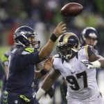 Seattle Seahawks quarterback Russell Wilson, left, passes under pressure St. Louis Rams' Eugene Sims in the second half of an NFL football game, Sunday, Dec. 27, 2015, in Seattle. The Rams won 23-17. (AP Photo/Stephen Brashear)