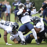 Seattle Seahawks running back Christine Michael twists for extra yardage as he carries the ball, Saturday, Aug. 2, 2014, during NFL football training camp in Renton, Wash. (AP Photo/Ted S. Warren)