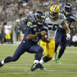 Seattle Seahawks quarterback Russell Wilson (3) scrambles as Green Bay Packers inside linebacker Brad Jones (59) pursues during the second half of an NFL football game, Thursday, Sept. 4, 2014, in Seattle. (AP Photo/Elaine Thompson)