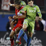 FC Dallas forward Tesho Akindele, left, Seattle Sounders FC midfielder Marco Pappa, right and Sounders defender Tyrone Mears, back, go up for a header during the overtime period of an MLS soccer western conference semifinal playoff match, Sunday, Nov. 8, 2015, in Frisco, Texas. Dallas won 4-2 on penalty kicks. (AP Photo/Brad Loper)