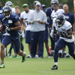Seattle Seahawks wide receiver Percy Harvin, left, runs with the ball after making a catch as free safety Steven Terrell, right, pursues, Saturday, Aug. 2, 2014, during NFL football training camp in Renton, Wash. (AP Photo/Ted S. Warren)