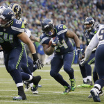 Seattle Seahawks, center, players open up a hole as Marshawn Lynch (24) rushes for a touchdown against the St. Louis Rams in the second half of an NFL football game, Sunday, Dec. 28, 2014, in Seattle. The Seahawks won 20-6. (AP Photo/Elaine Thompson)