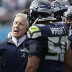 Seattle Seahawks head coach Pete Carroll speaks with Seattle Seahawks outside linebacker K.J. Wright (50) on the sidelines during the first half of an NFL divisional playoff football game against the Carolina Panthers, Sunday, Jan. 17, 2016, in Charlotte, N.C. (AP Photo/Bob Leverone)