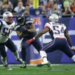 Seattle Seahawks running back Marshawn Lynch (24) runs between New England Patriots defensive end Rob Ninkovich (50) and outside linebacker Dont'a Hightower (54) during the first half of NFL Super Bowl XLIX football game Sunday, Feb. 1, 2015, in Glendale, Ariz. (AP Photo/Matt Rourke)