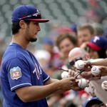 Texas Rangers pitcher Yu Darvish signs autographs before a spring training baseball game against the Seattle Mariners Sunday, March 6, 2016, in Surprise, Ariz. (AP Photo/Charlie Riedel)