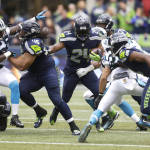 Seattle Seahawks running back Marshawn Lynch (24) rushes the ball as teammate Will Tukuafu (46) blocks Carolina Panthers' Thomas Davis (58) in the first half of an NFL football game, Sunday, Oct. 18, 2015, in Seattle. (AP Photo/Stephen Brashear)