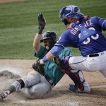Seattle Mariners' Chris Taylor is forced out at home by Texas Rangers catcher Chris Gimenez as he tried to score on a fielders choice hit into by Nori Aoki during the sixth inning of a spring training baseball game Sunday, March 6, 2016, in Surprise, Ariz. (AP Photo/Charlie Riedel)