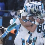 Carolina Panthers quarterback Cam Newton (1) leaps into the arms of Carolina Panthers tight end Greg Olsen (88) after a touchdown against the Seattle Seahawks during the first half of an NFL divisional playoff football game, Sunday, Jan. 17, 2016, in Charlotte, N.C. (AP Photo/Chuck Burton)