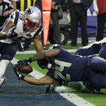 Seattle Seahawks running back Marshawn Lynch (24) dives into the end zone for a touchdown in front of New England Patriots cornerback Brandon Browner (39) during the first half of NFL Super Bowl XLIX football game Sunday, Feb. 1, 2015, in Glendale, Ariz. (AP Photo/David J. Phillip)