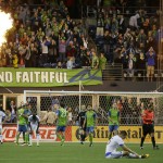 Seattle Sounders players celebrate as Montreal Impact defender Donny Toia sits on the pitch after the Sounders defeated the Impact 1-0 in an MLS soccer match, Saturday, April 2, 2016, in Seattle. (AP Photo/Ted S. Warren)